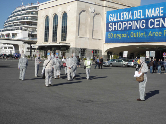 Attivisti del "Comitato Pace, Disarmo e Smilitarizzazione del Territorio - Campania" al porto di Napoli con tute bianche e maschere antigas si avviano verso il centro commerciale "La galleria del mare"